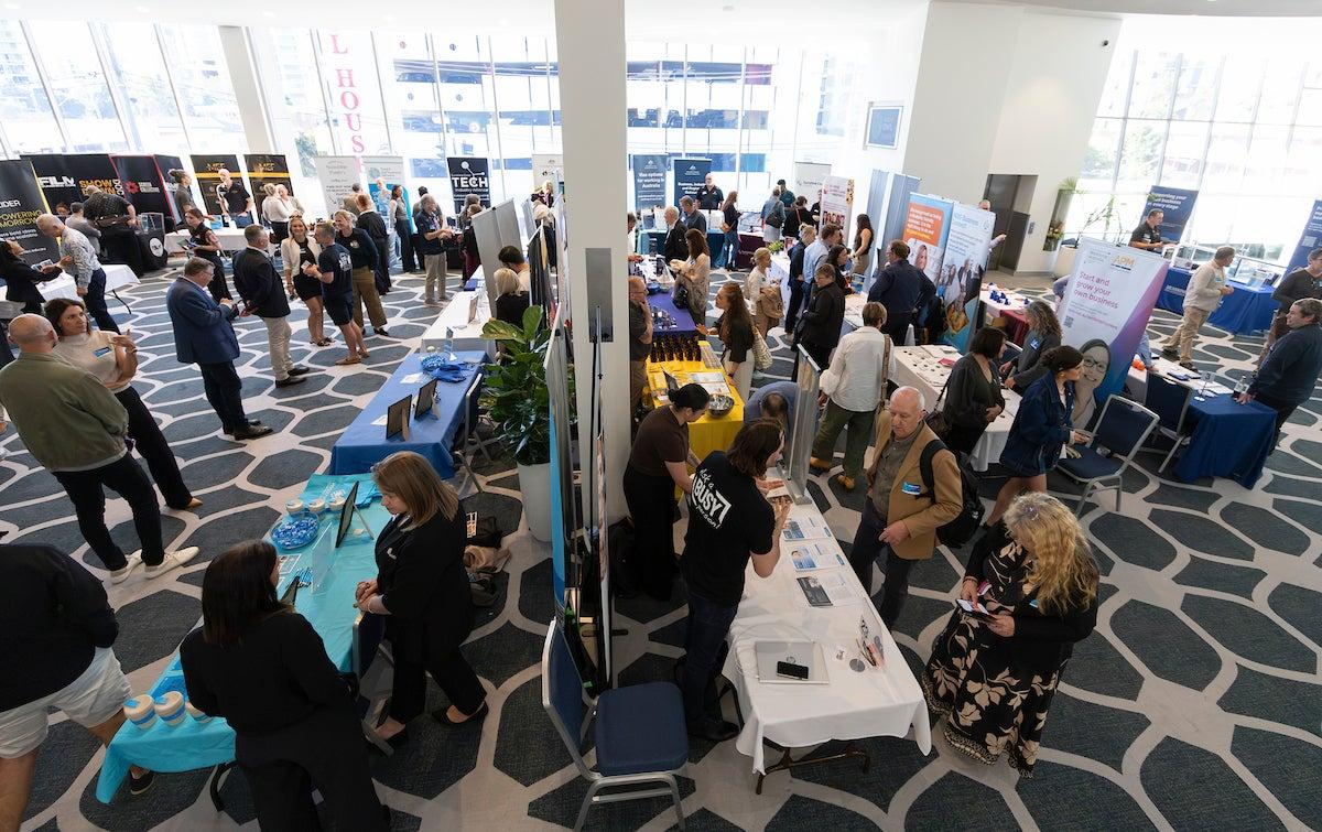 People at the Thriving Through Change event talk to exhibitors.