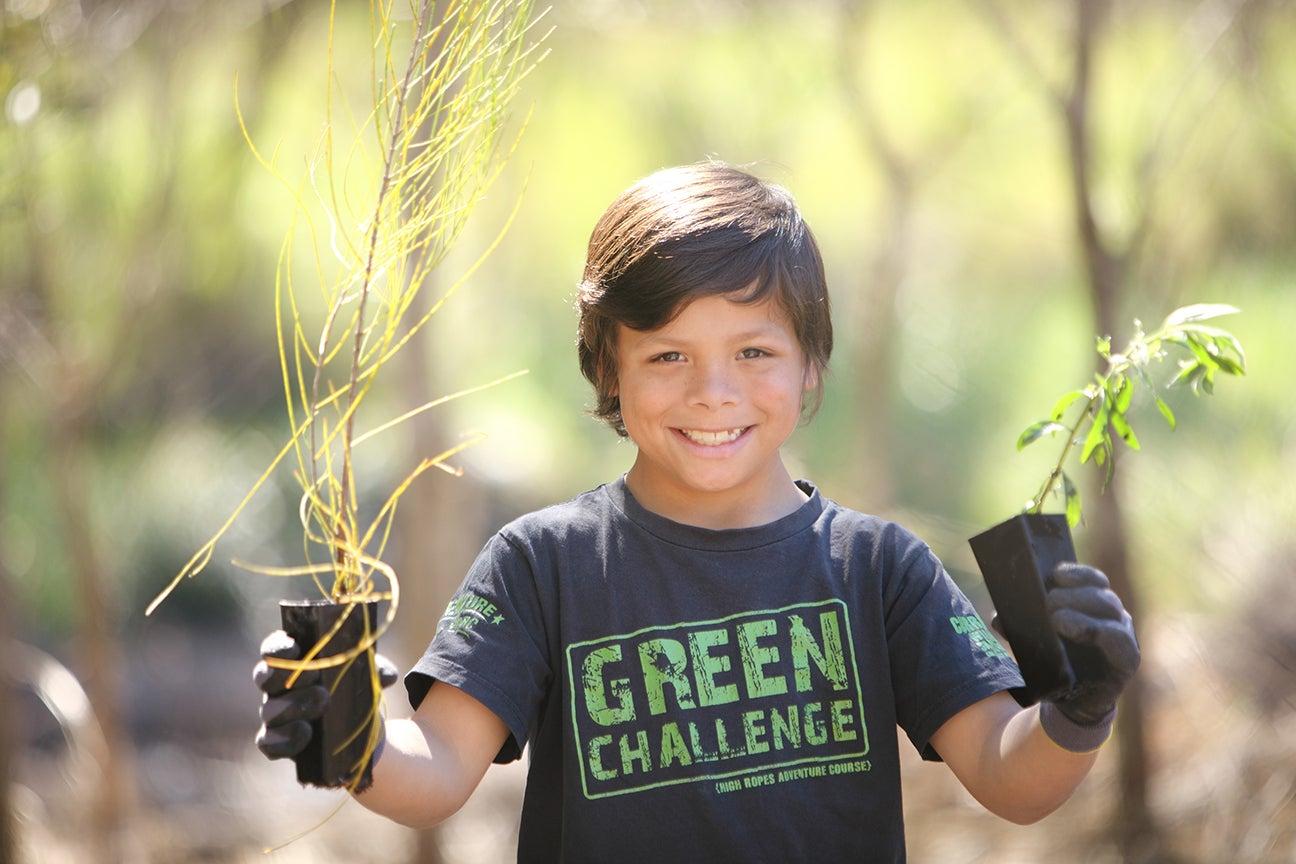 young person holding potted seedlings in both hands