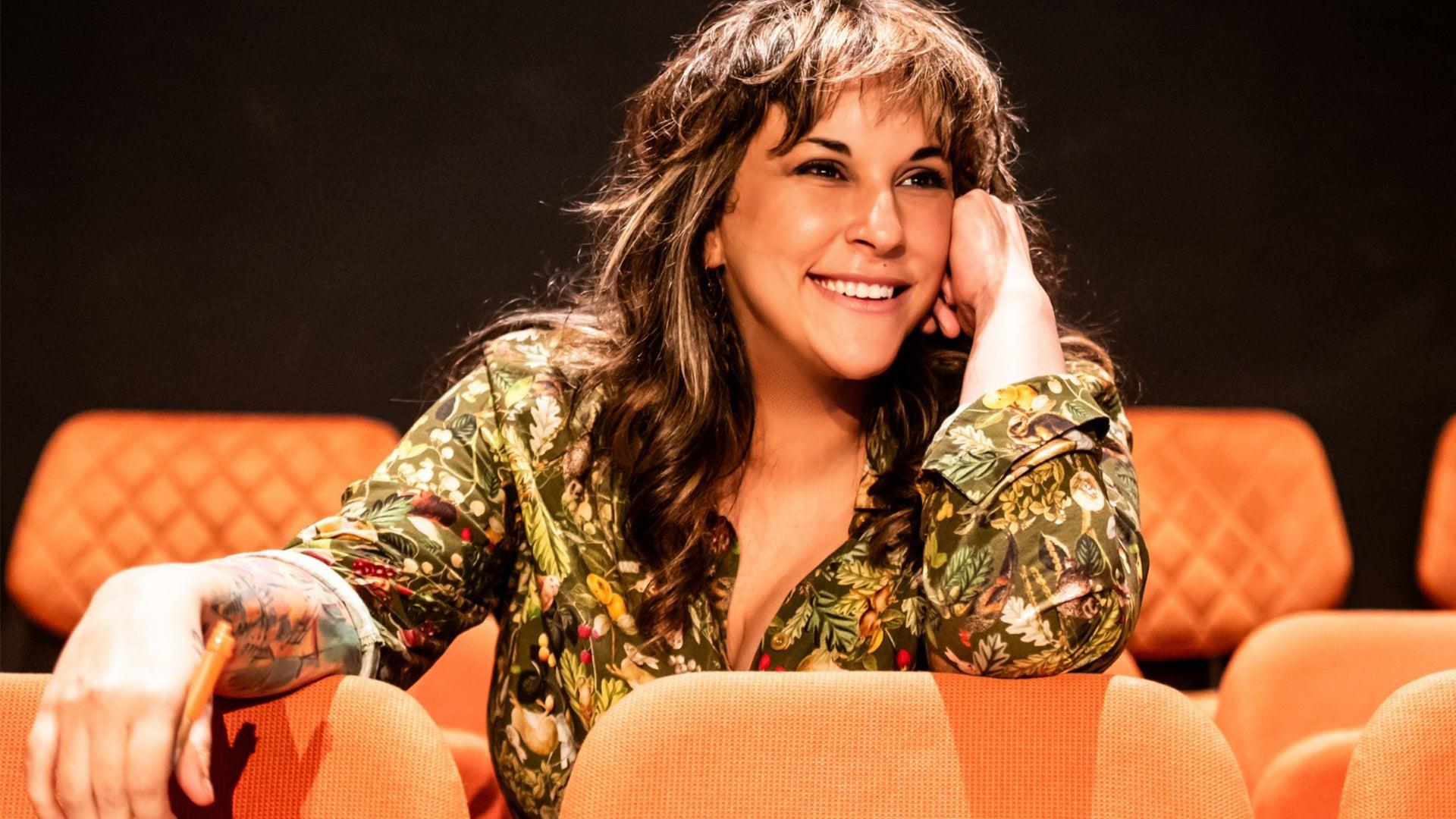 Bec Martin sitting in a theatre with orange seats