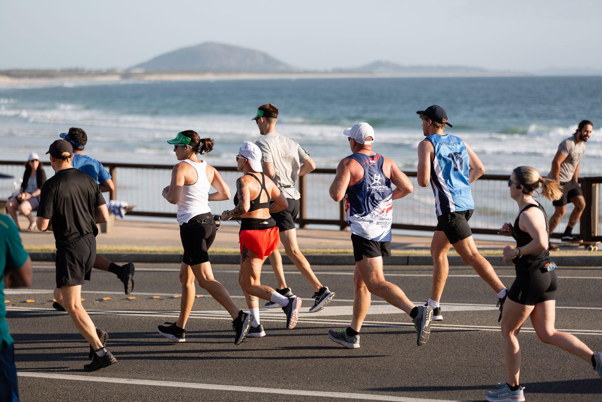 Sunshine Coast Marathon - runners along the coast line in the foreground, ocean and Mt Coolum in the background