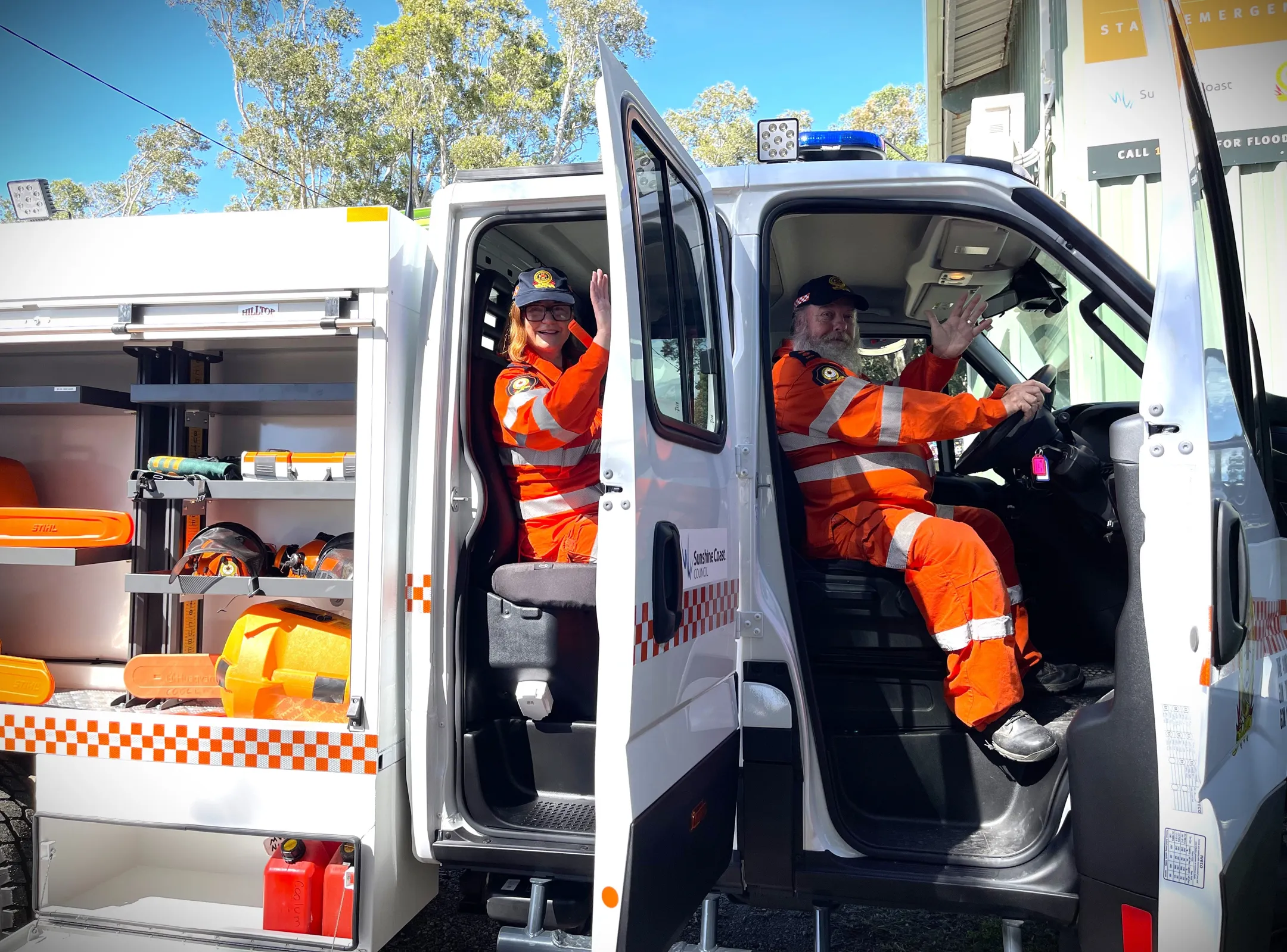 Two SES volunteers' wave from inside the new SES vehicle.