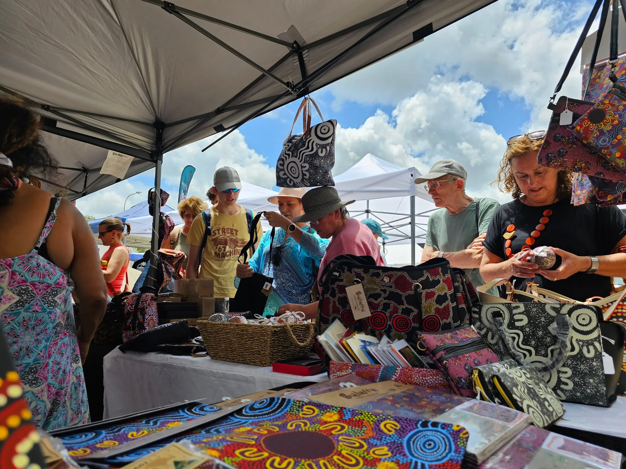Crowds browse a market stall.