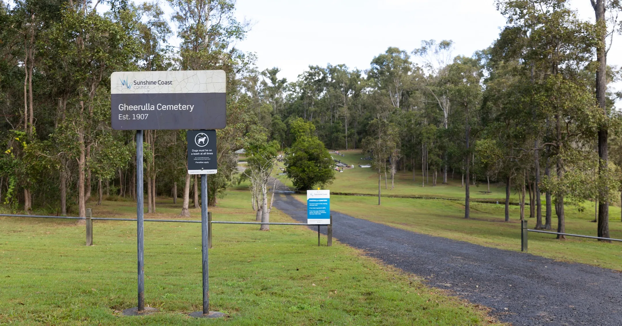 Driveway into cemetery, with a location sign stating 'Gheerulla Cemetery' on the left hand side of the driveway
