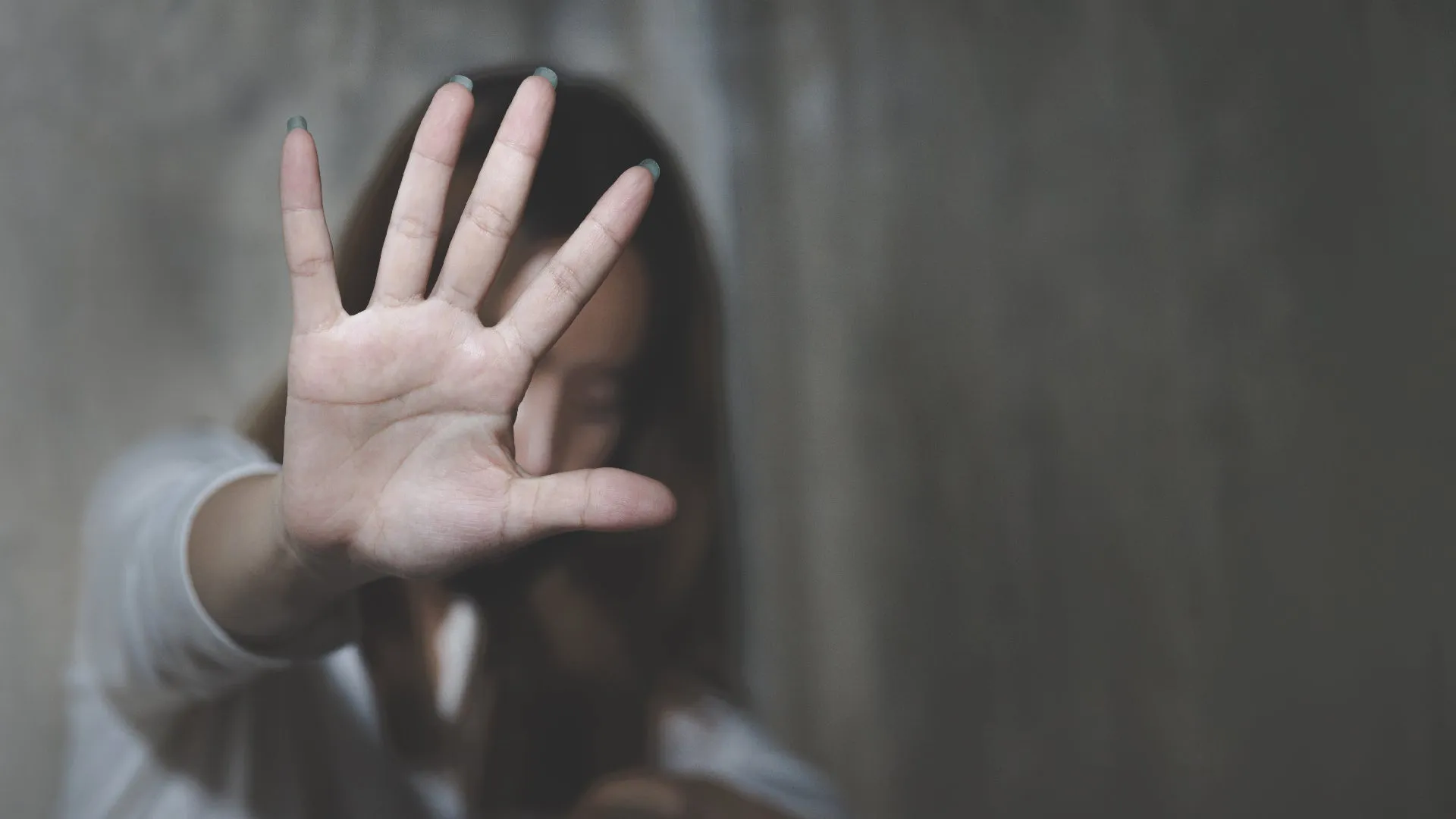 Woman with raised hand to stop violence against women.