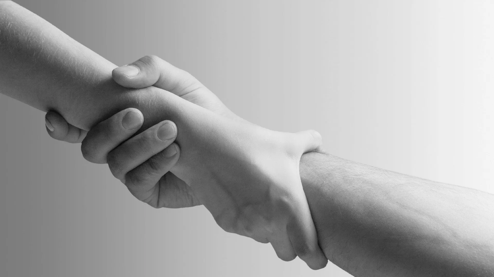 Two hands holding each other and helping.