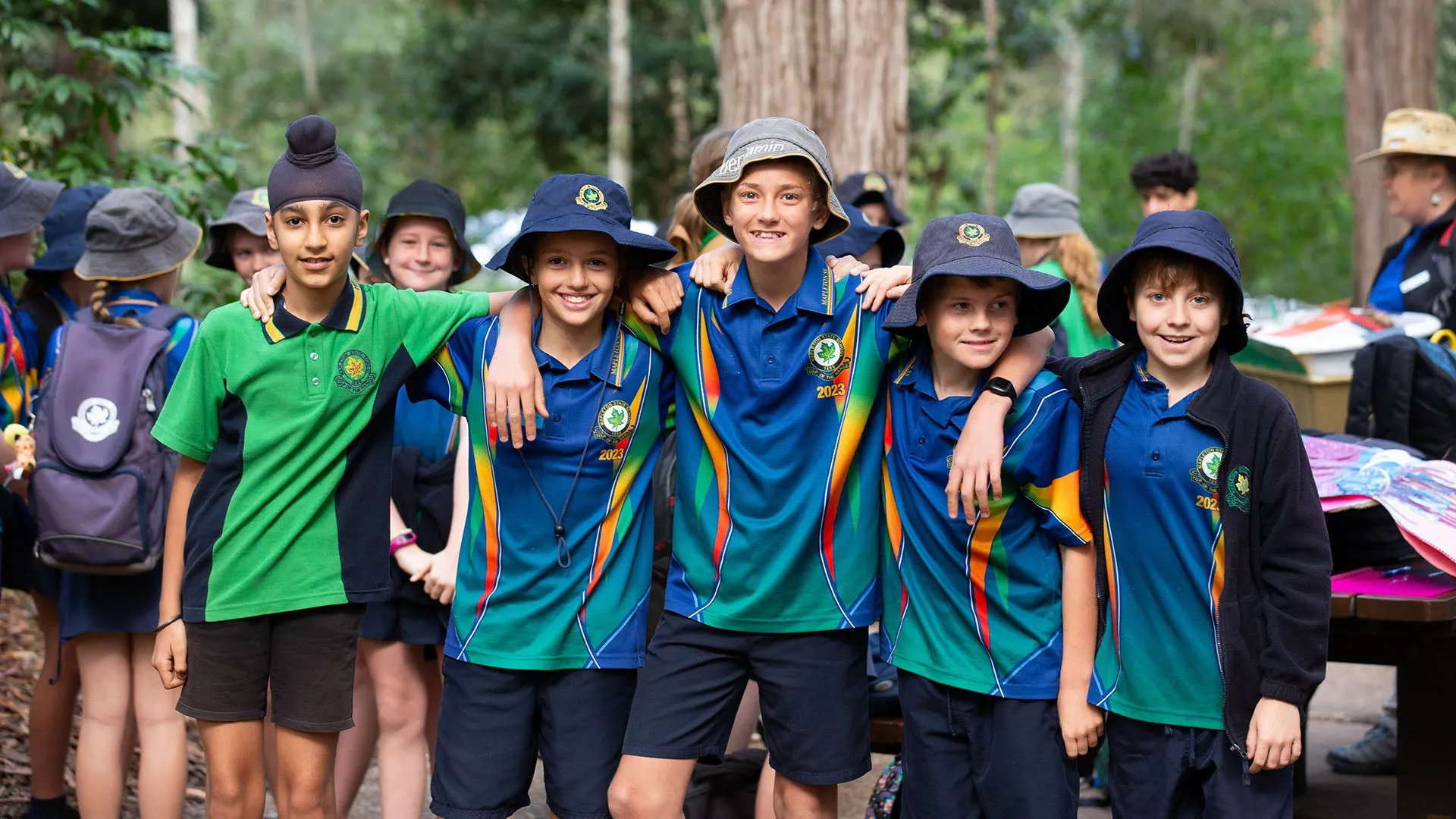 group of 5 students standing together with arms around shoulders