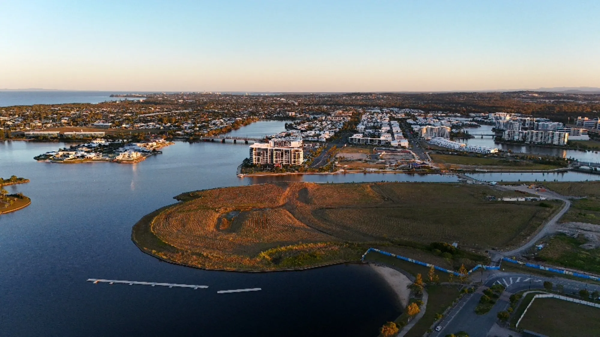 Aerial view of Birtinya. Showing the canals and land space and residential area with blue skies and horizon view.