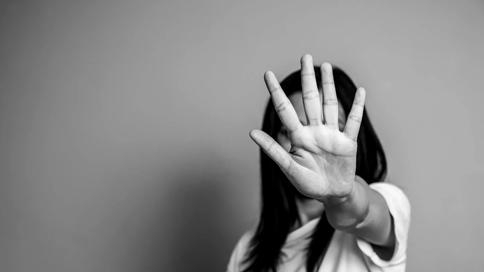 Woman with raised hand to stop violence against women.