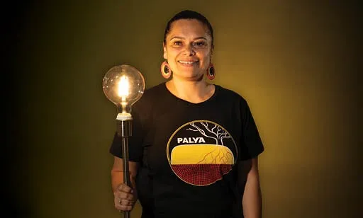 Proud Aboriginal lady holding a light up to racism