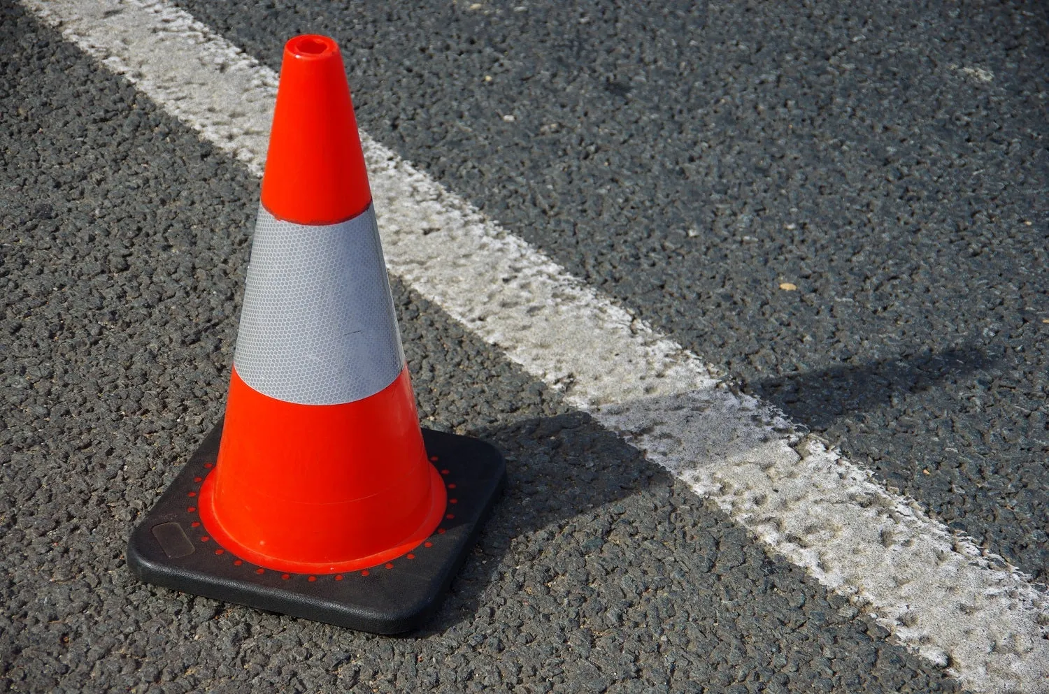 Single cone on tarred road.