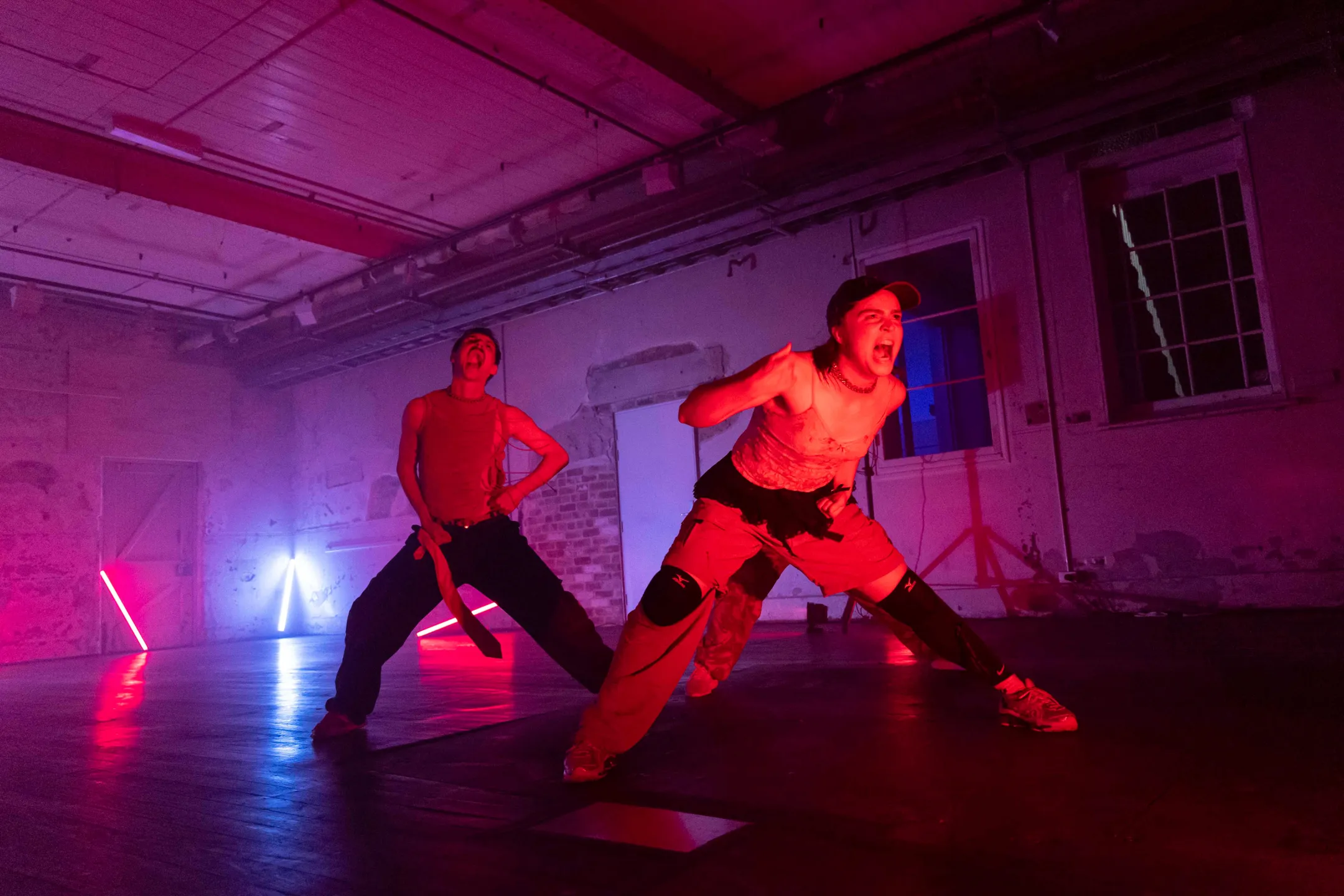 Two performers with a backdrop of darkness and bright lights.