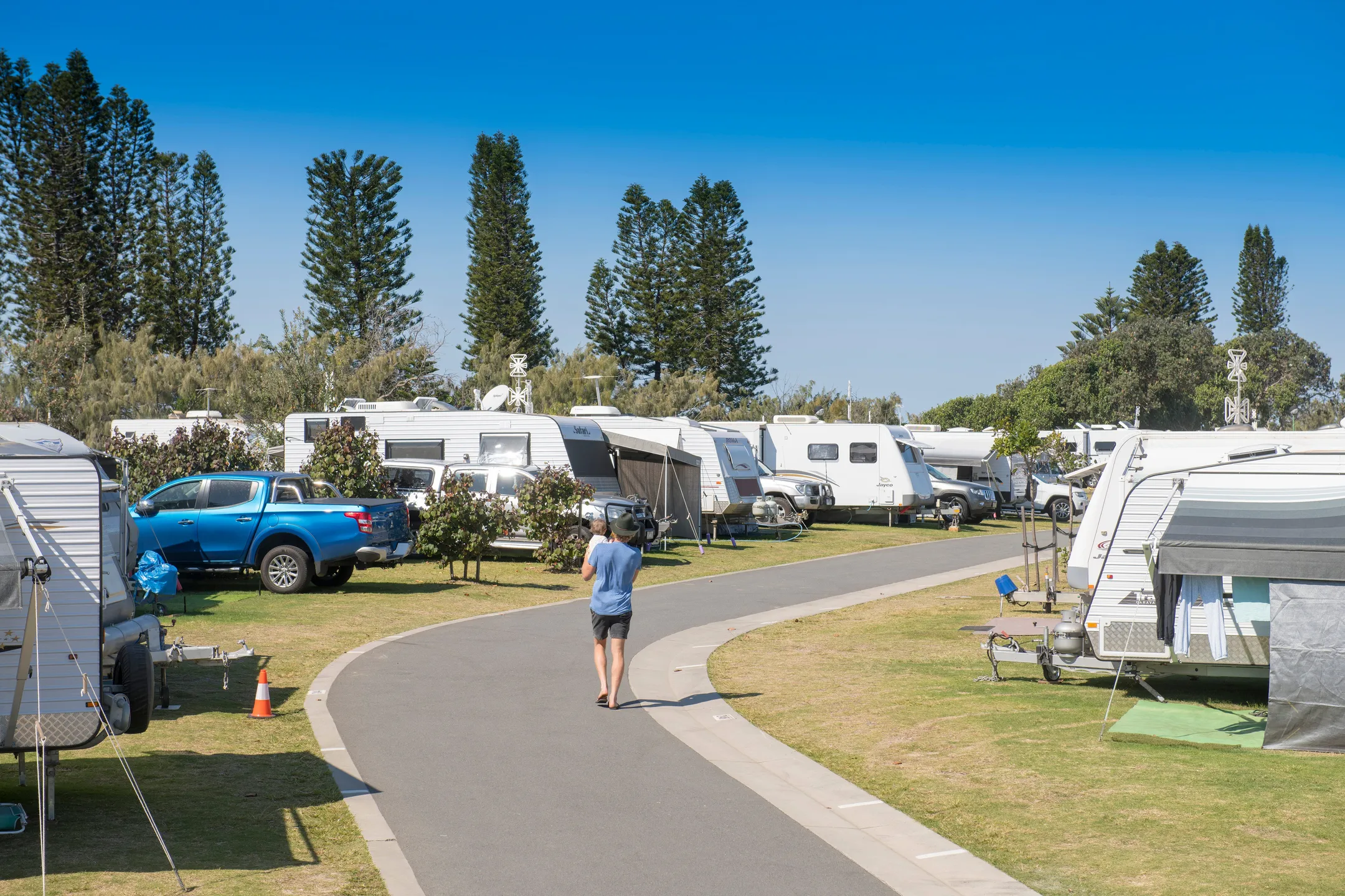 At Coolum caravan park, a father and son walked along the road, passing caravans parked in their allocated spots.
