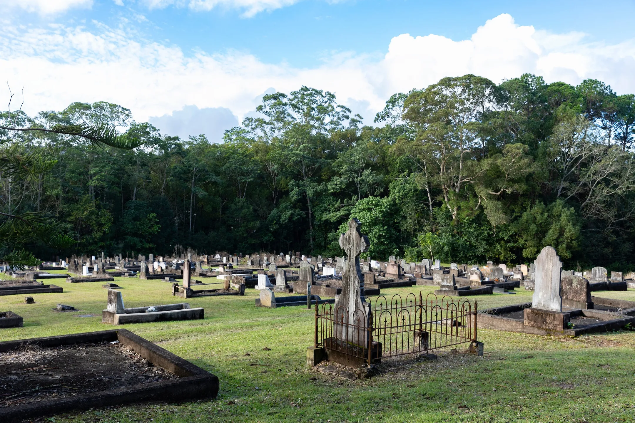Monumental burial section at Old Nambour Cemetery in foreground, bushland in background