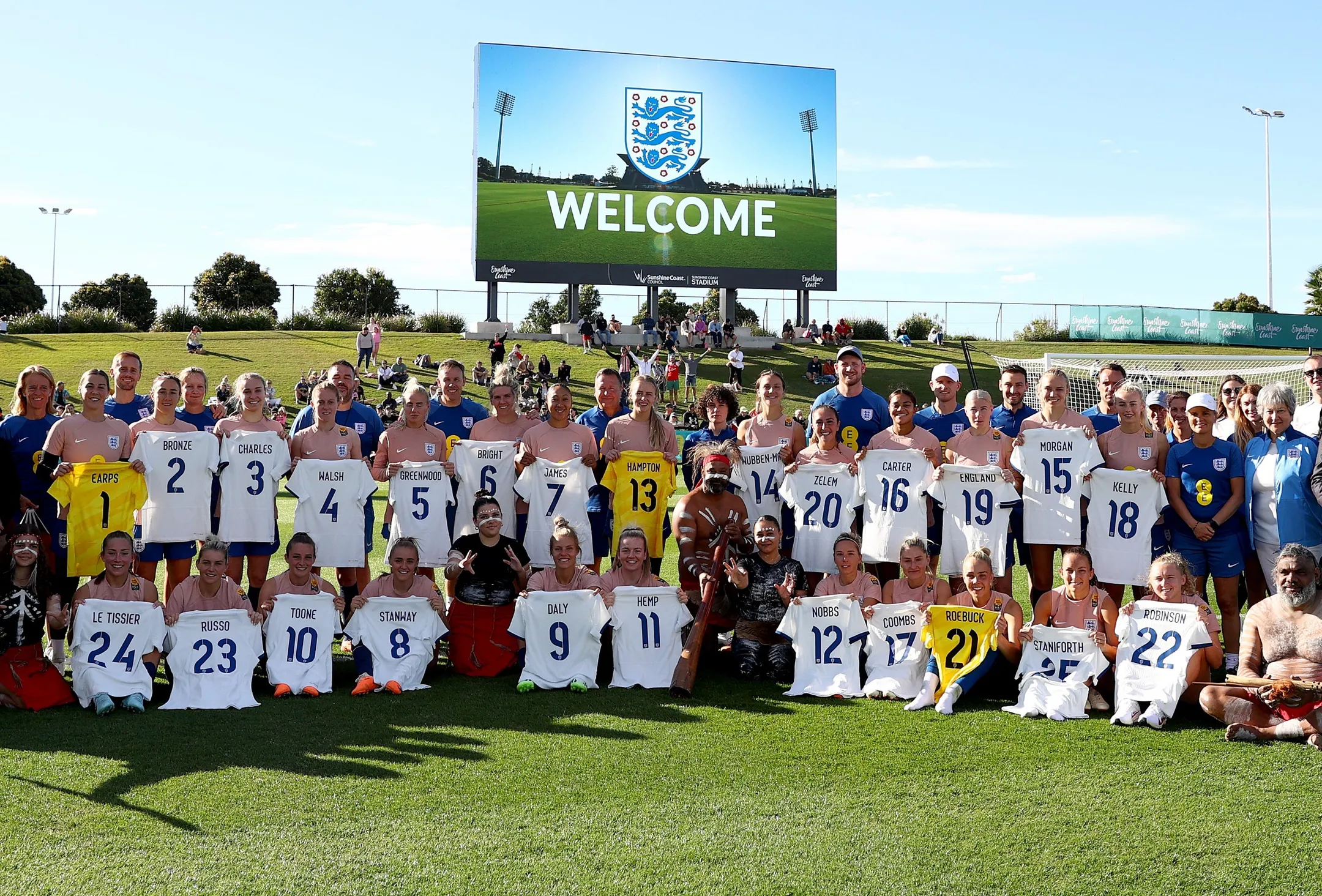 A group photograph of the England Lioness players, coaches and First Nations people at a welcome event held at the Sunshine Coat Stadium