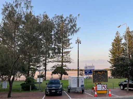 Trailer with mast up parked in carpark near beach