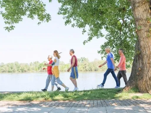 Walking group walking alongside of a river.