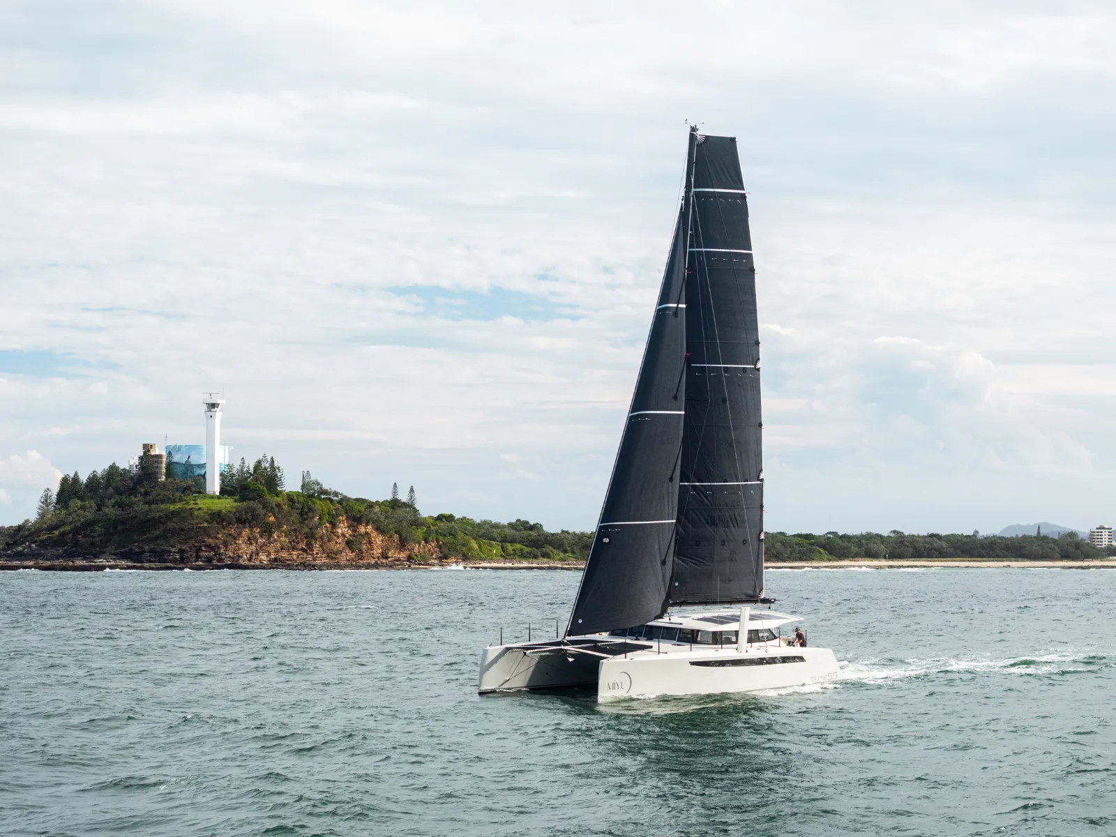 Cure Marine Cure 55 catamaran Miyu. On the water lighthouse in the distance.
