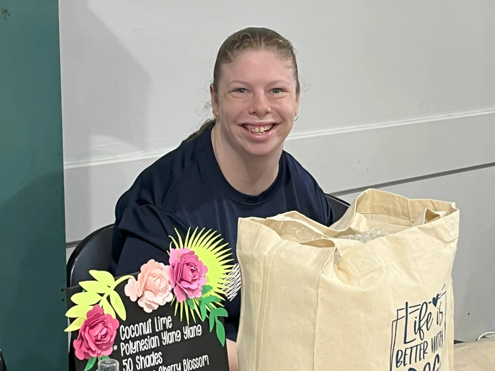 Person smiling sitting at a market stall table