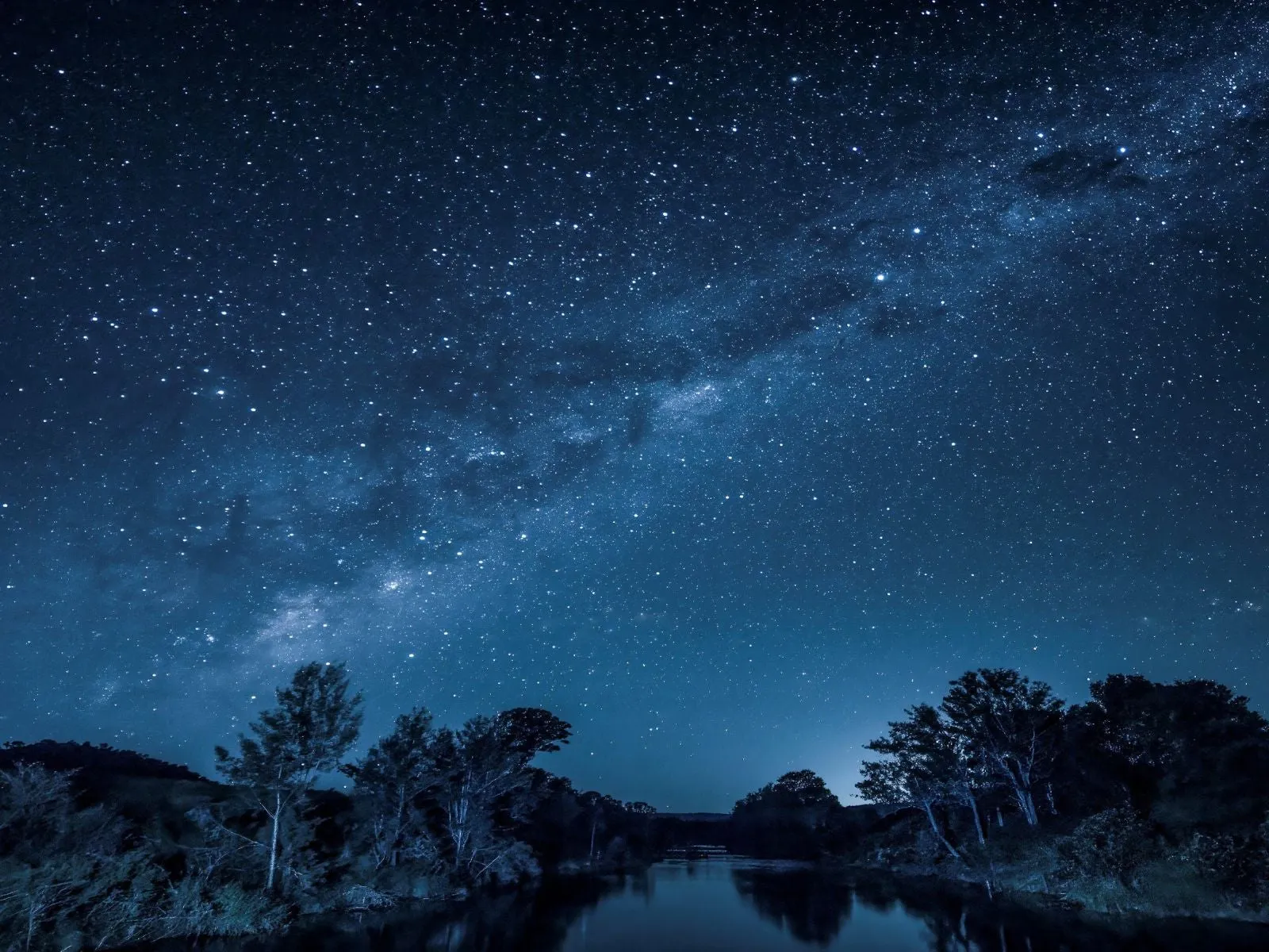 The Milky Way at night over a river