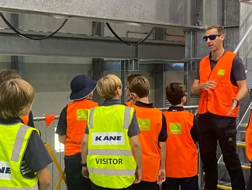 Guide taking children on a tour through a facility.
