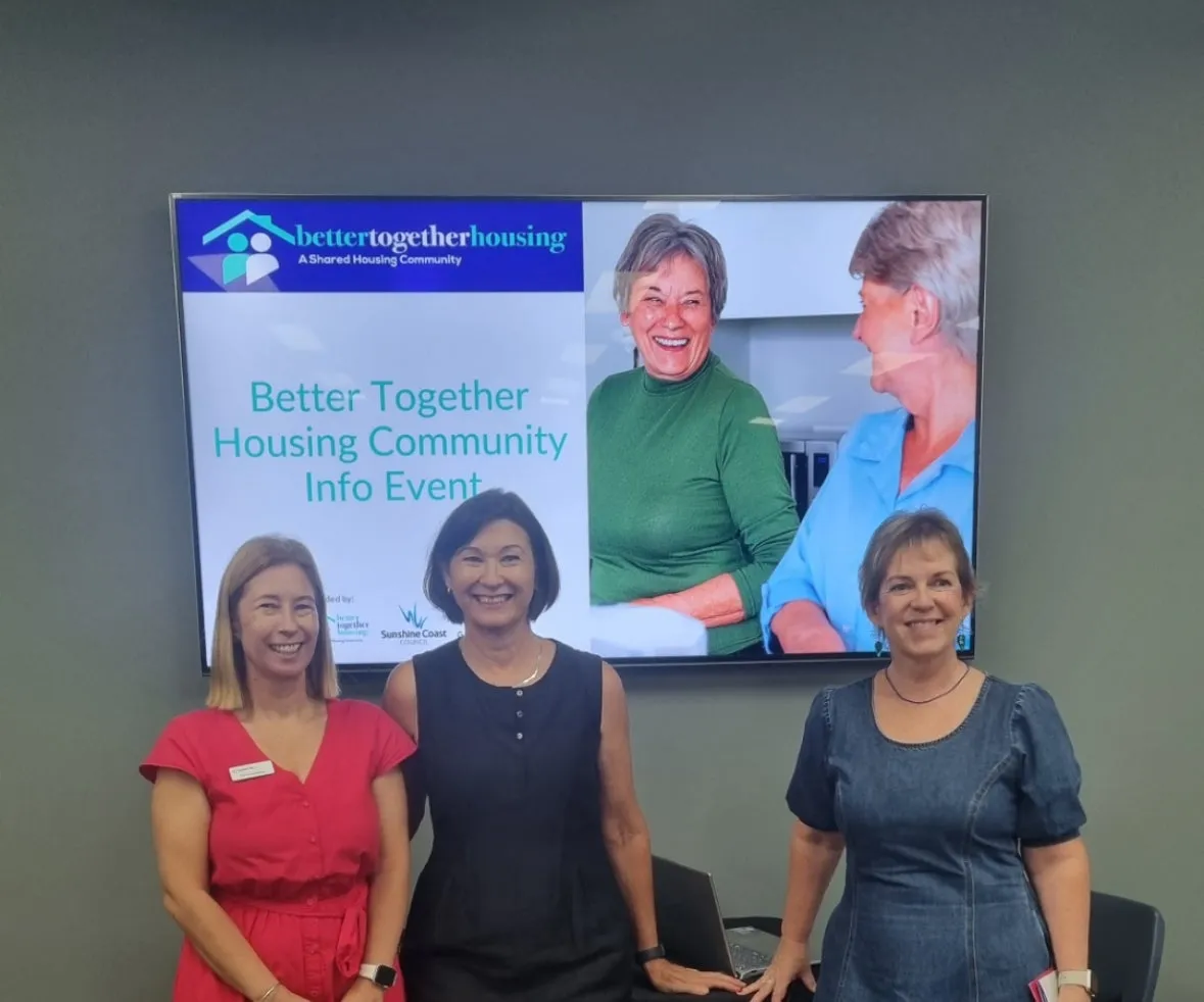 Three women standing in front of a screen showcasing Better Together Housing