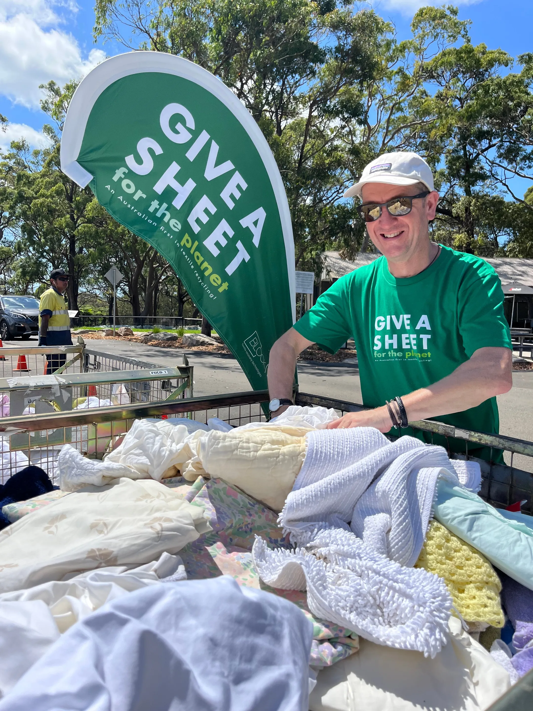 man donating old bedding to Give a Sheet camping