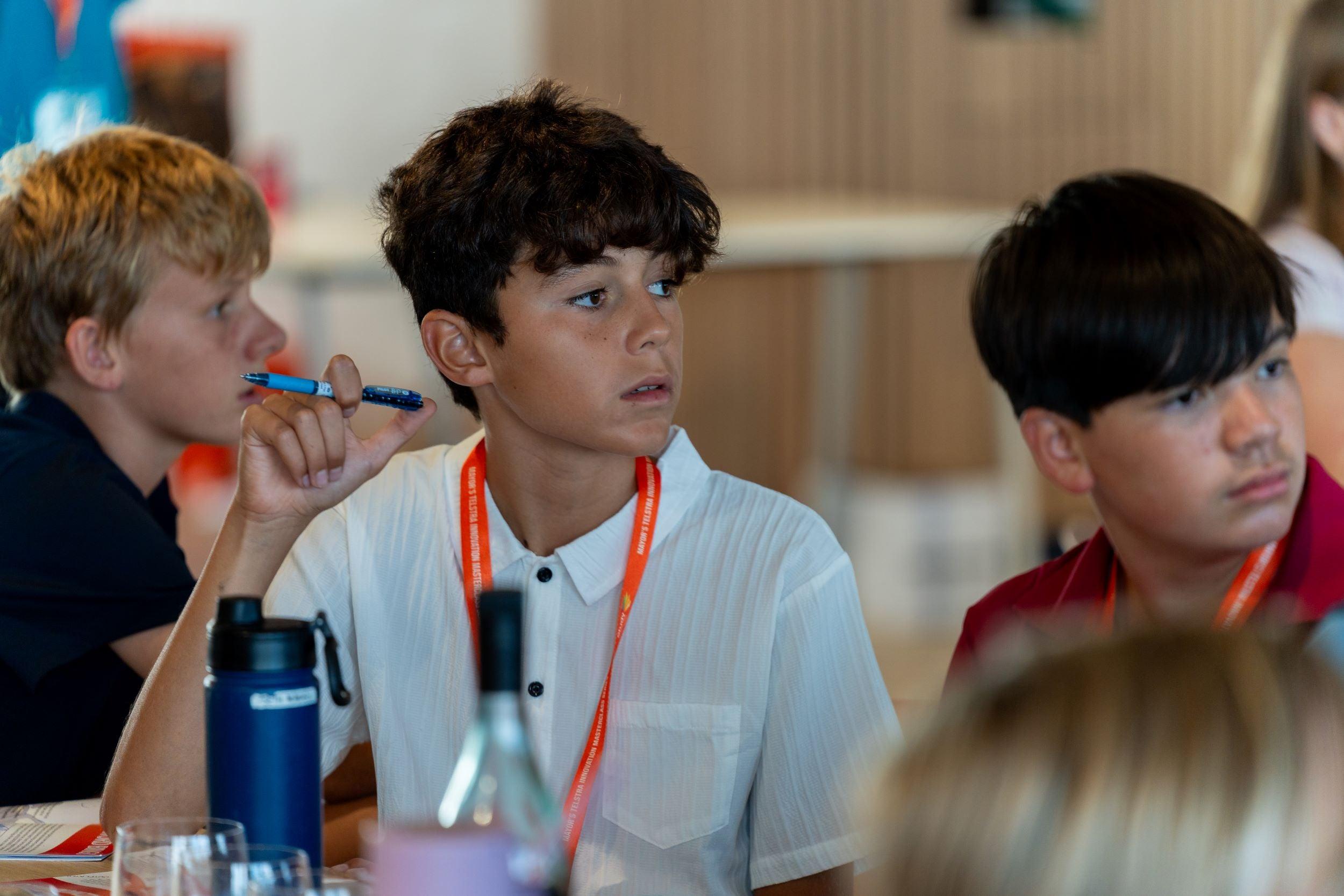 Three seated students, looking towards the facilitator