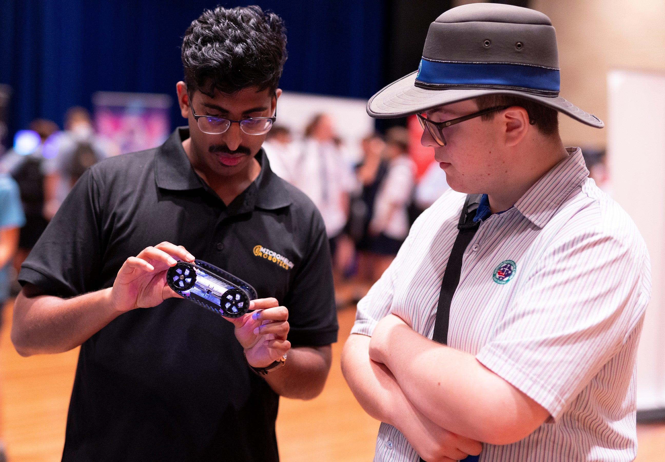 A student being shown a technical gadget.