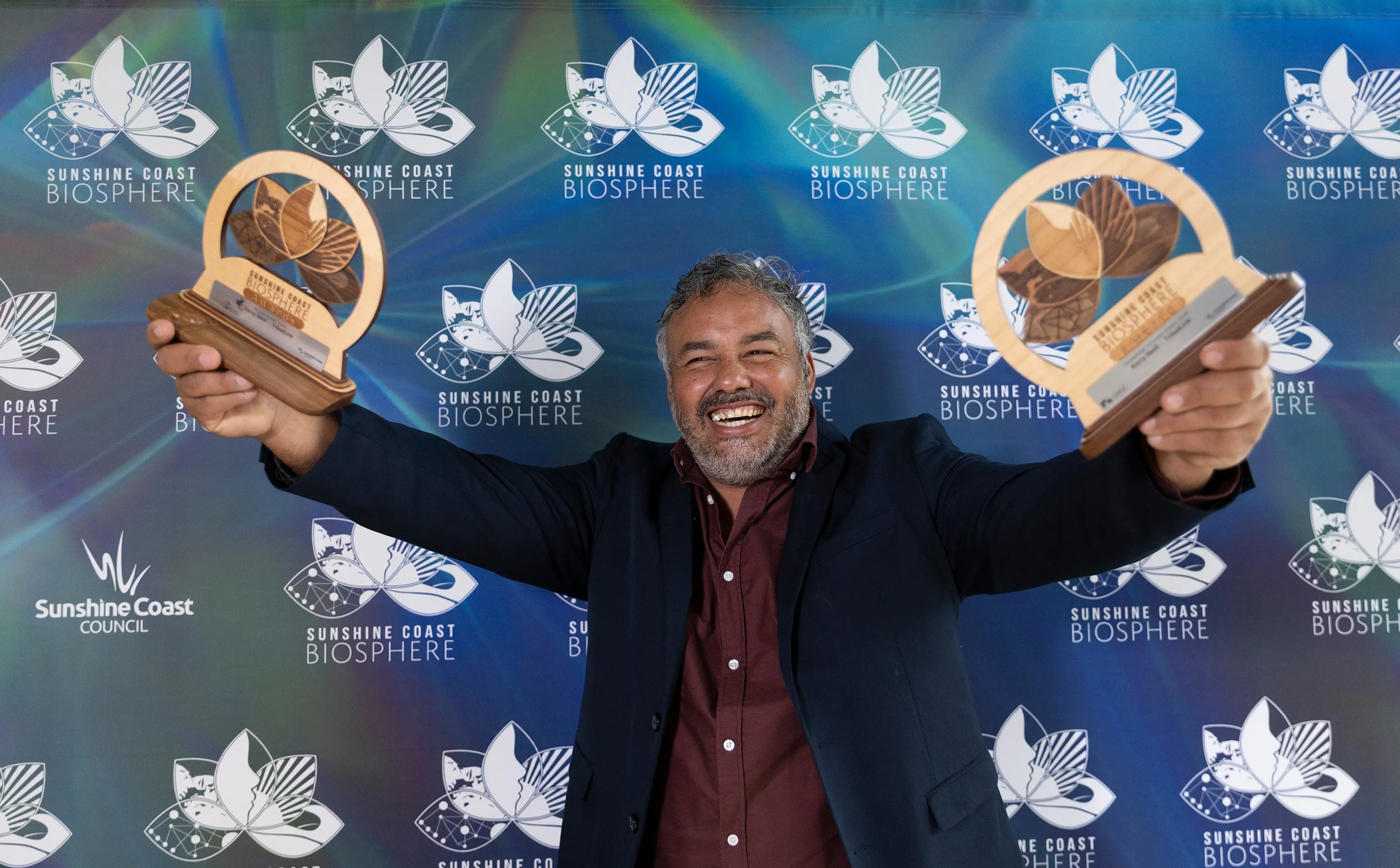 Kerry Neill holds up two trophies.
