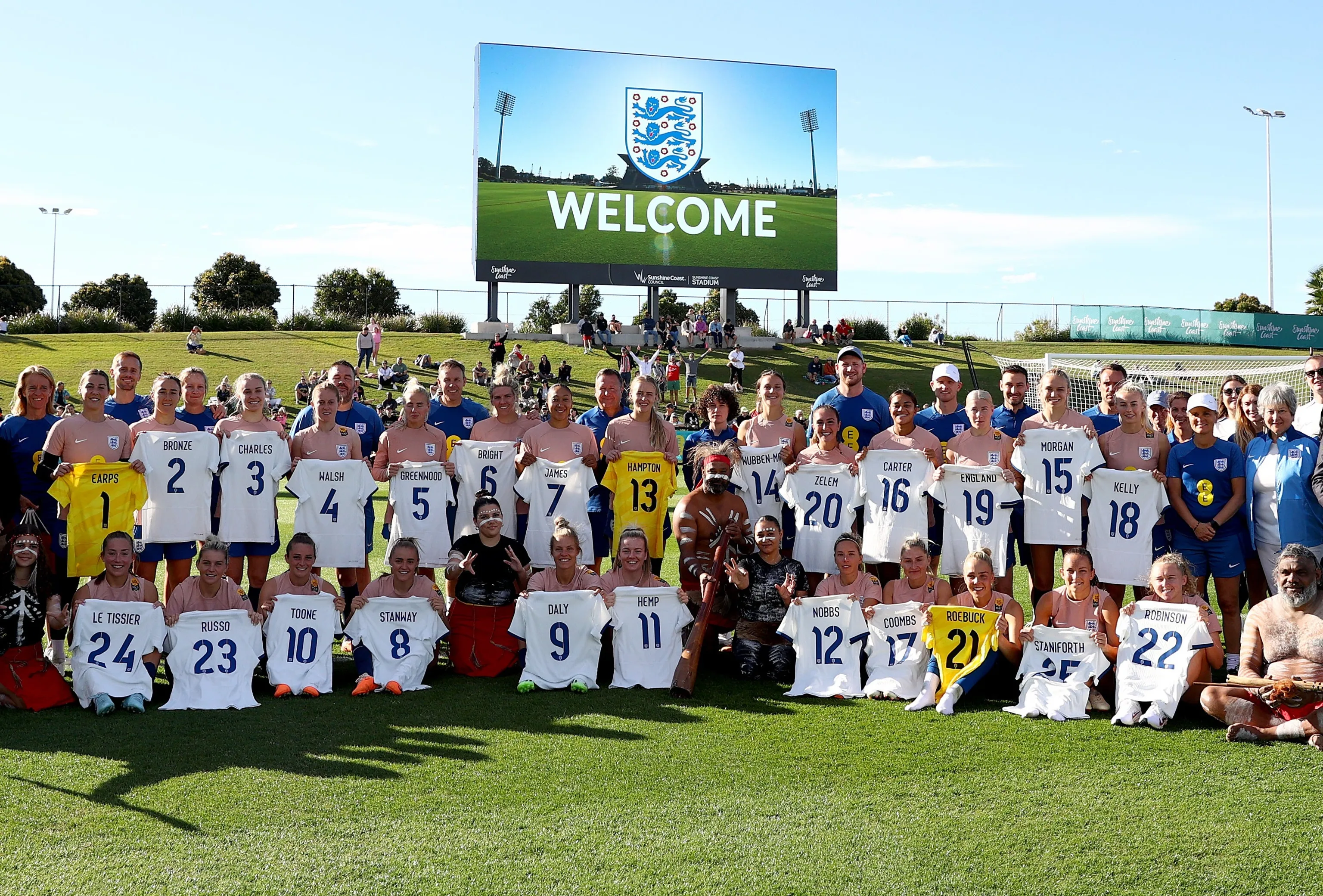 A group photograph of the England Lioness players, coaches and First Nations people at a welcome event held at the Sunshine Coat Stadium