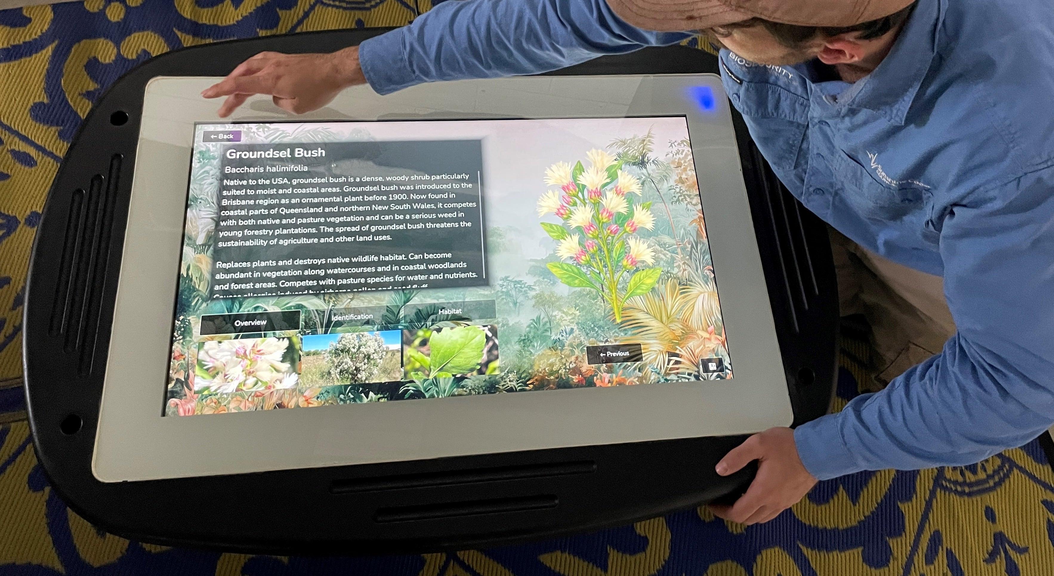 Biosecurity education touch screen with Council officer demonstrating use