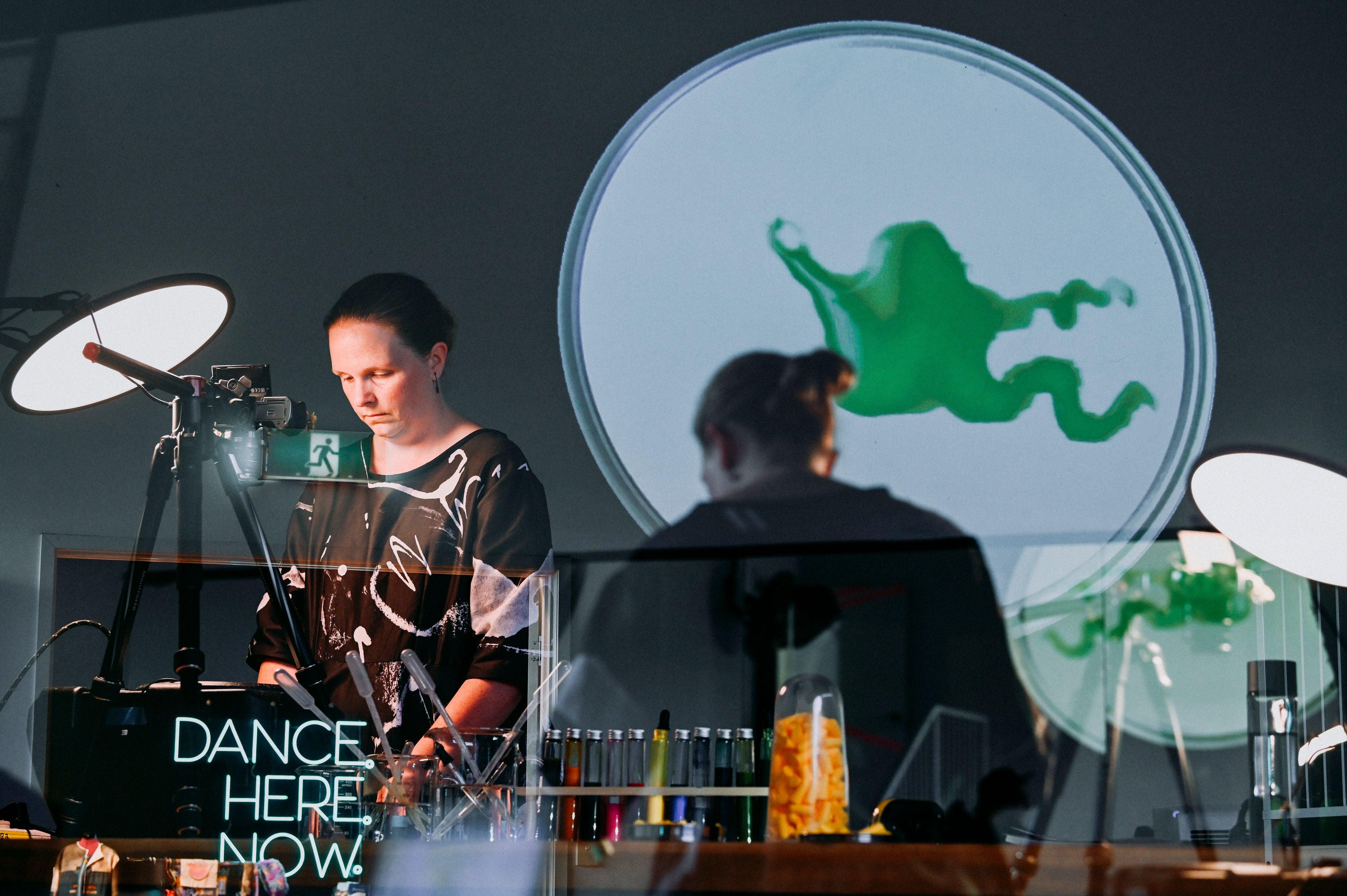 Image shows an artists creating works with colour