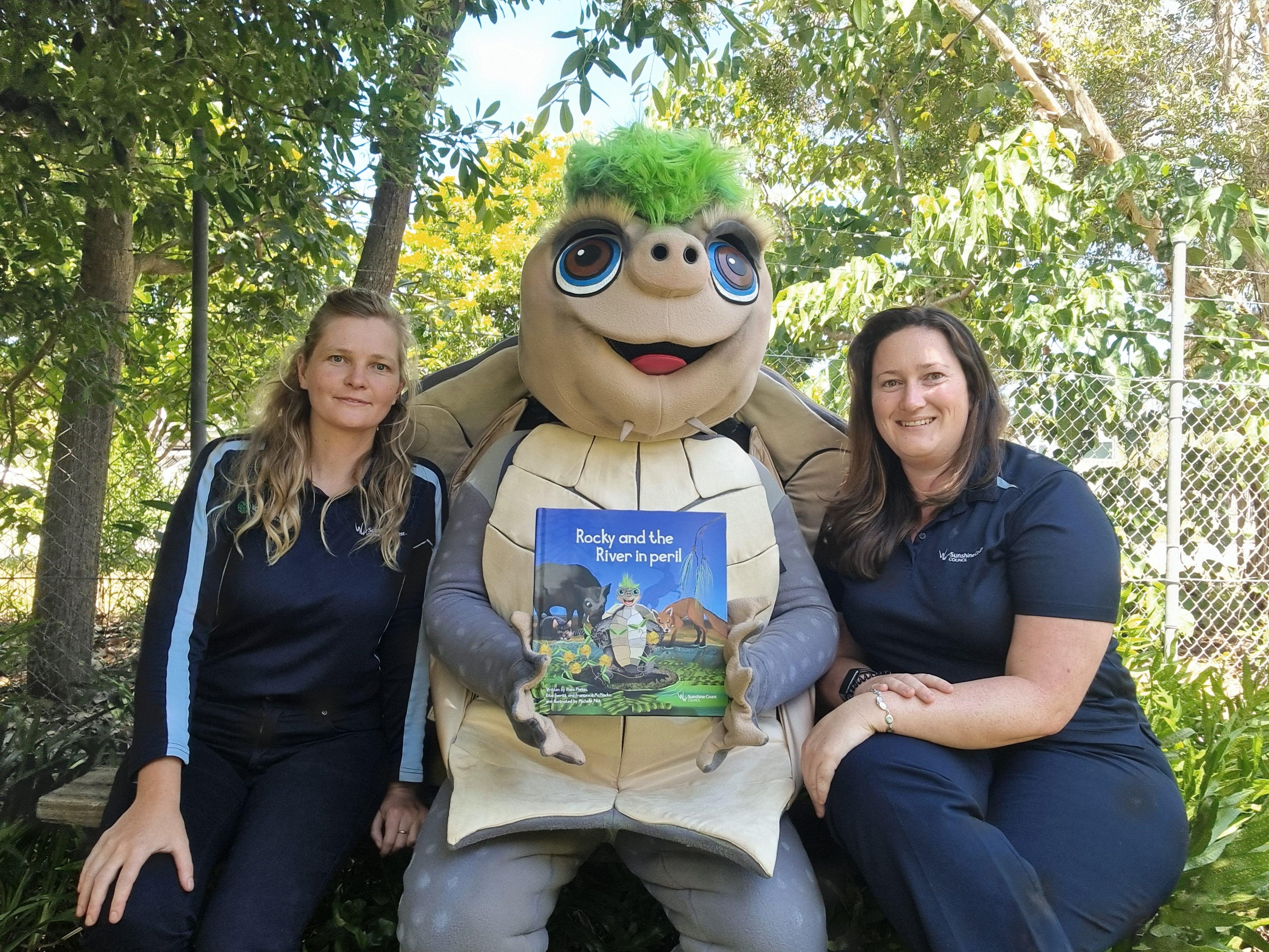 Authors Rita and Rhea with 'Rocky' the Mary River turtle mascot holding their book