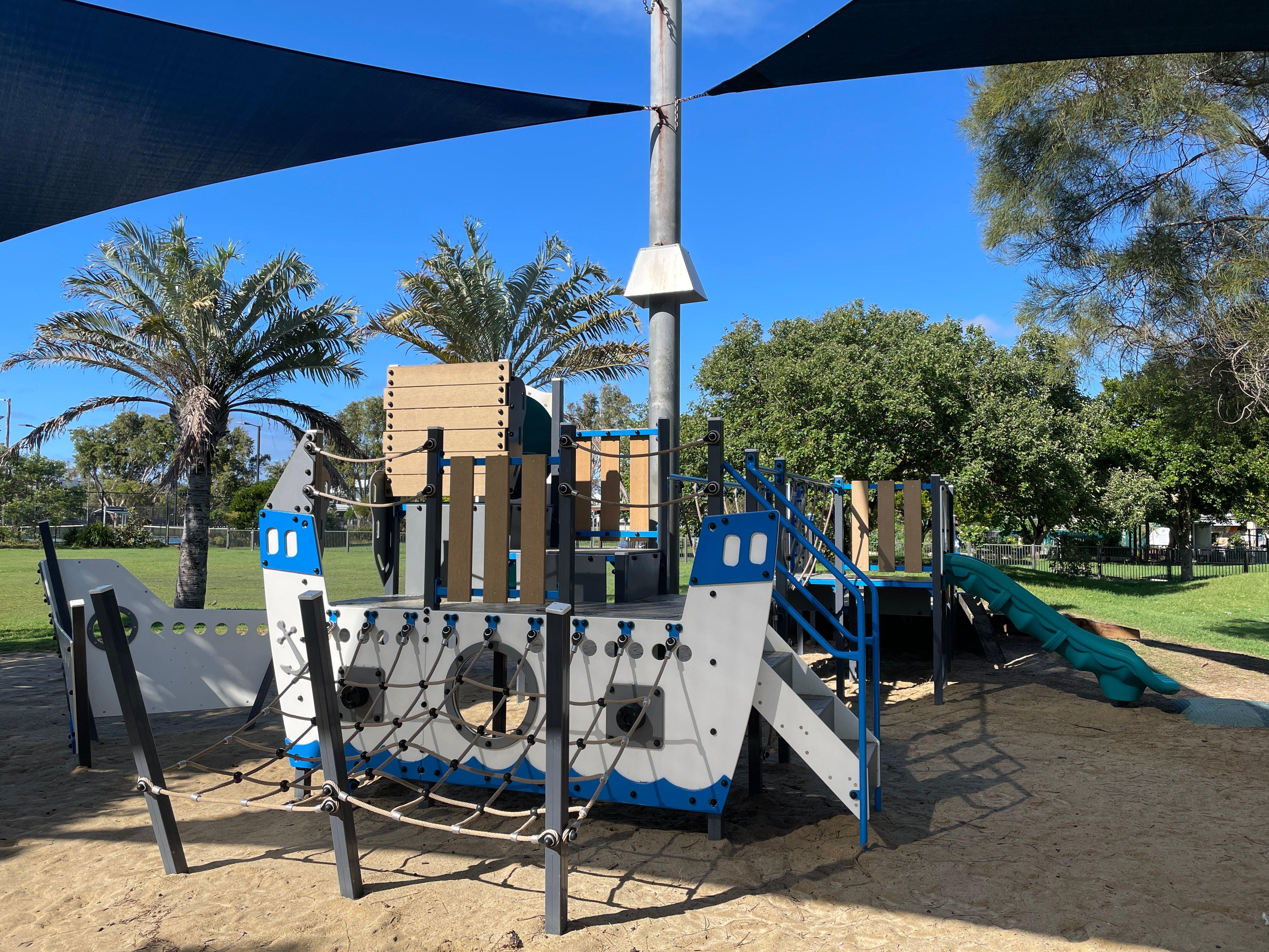 Pirate ship themed playground with climbing ropes and slide on sand